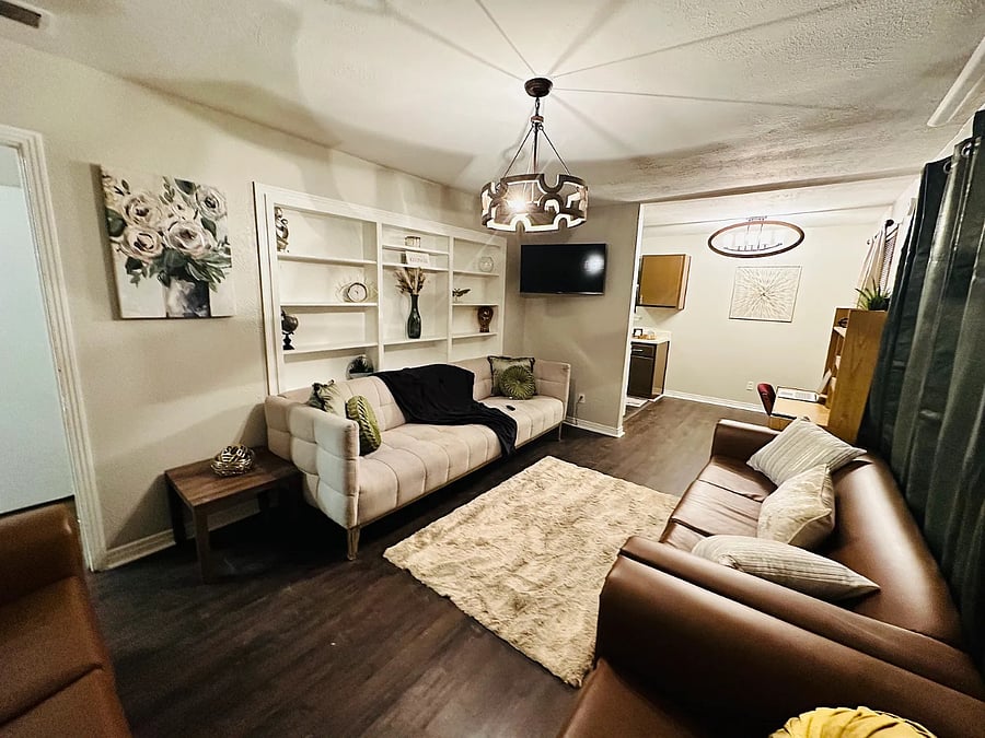 Relax in the bright and airy living room, featuring comfortable leather seating and an open-concept layout. The perfect space to unwind, watch your favorite shows, or enjoy a quiet evening after work.
