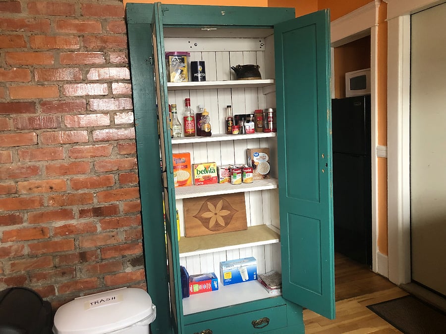 There is a large pantry cupboard next to the exposed brick wall in your kitchen 