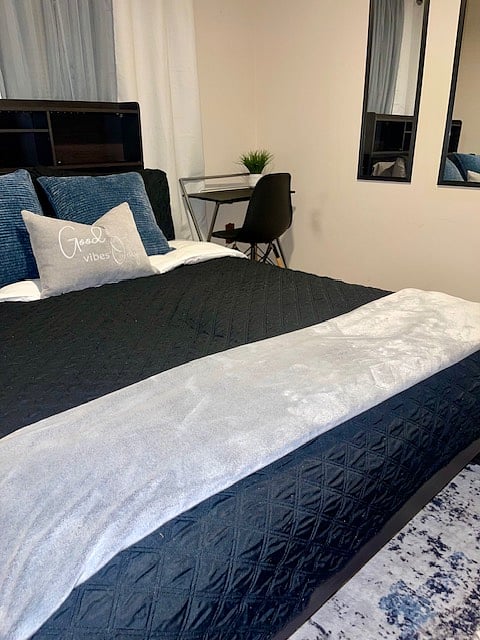 Stay in the Cozy Grey Room, a stylish and comfortable retreat featuring a smart TV, study desk, remote-controlled ceiling fan, and blackout curtains for the perfect nights sleep.