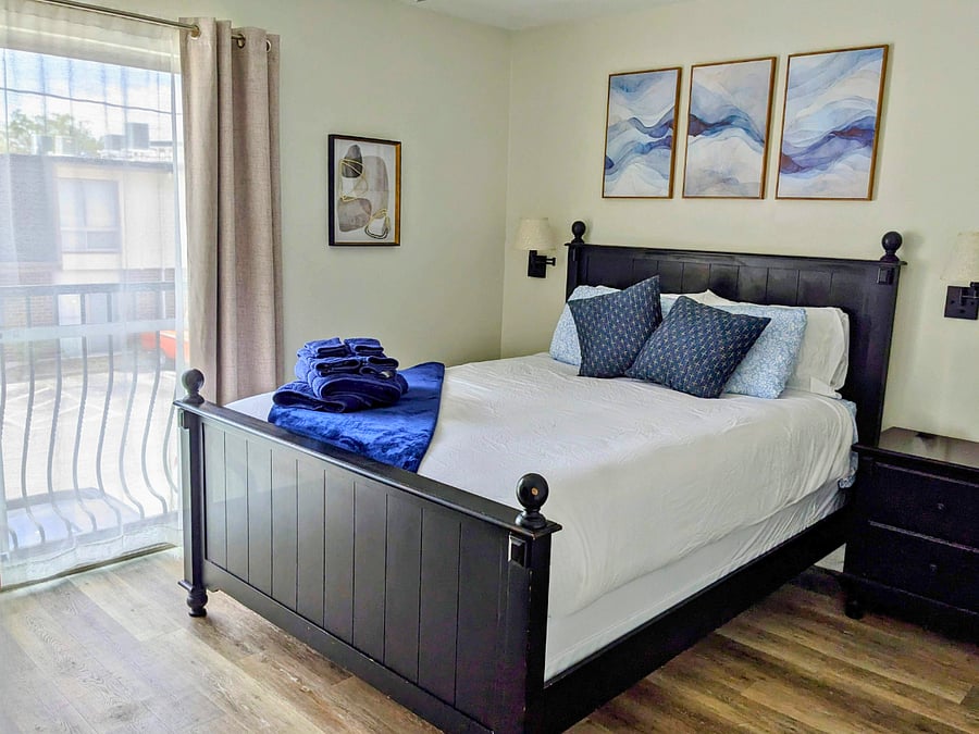 Quiet bedroom designed for restful sleep after long clinical days. Blackout curtains, cool cotton sheets, ceiling fan, and available white noise machine, sleep masks and ear plugs.