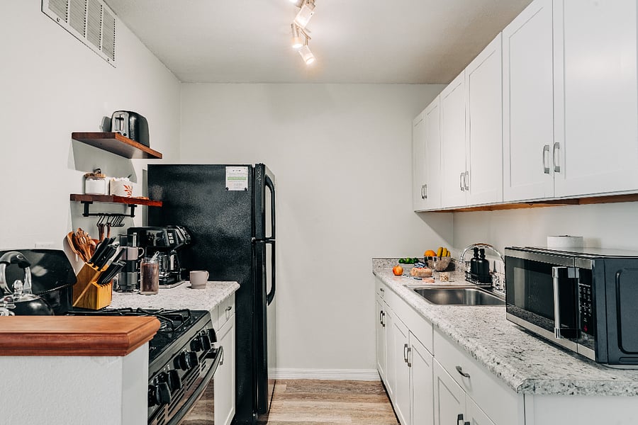 Fully equipped kitchen with full-sized appliances, microwave, toaster, cookware, dishes, and stocked coffee station for an easy month-long stay.