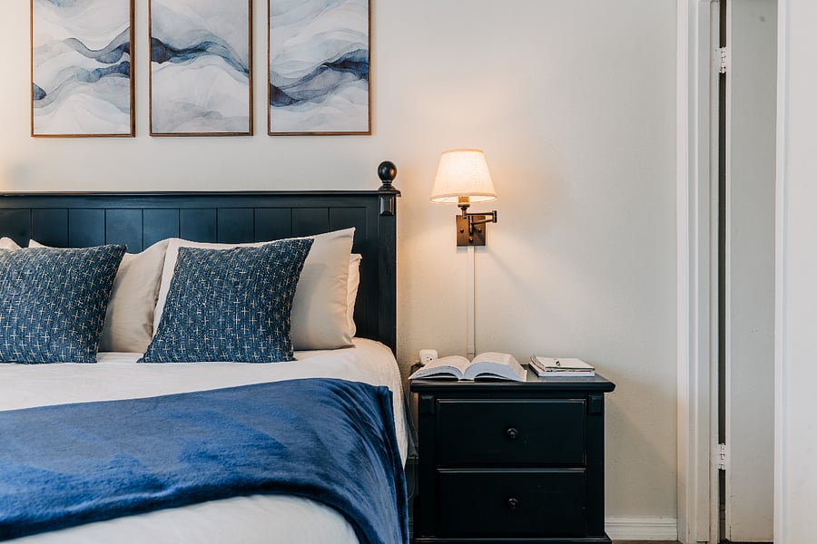 Comfortable bed with attention to detail - linens, pillows, sconces, chargers, night stands.