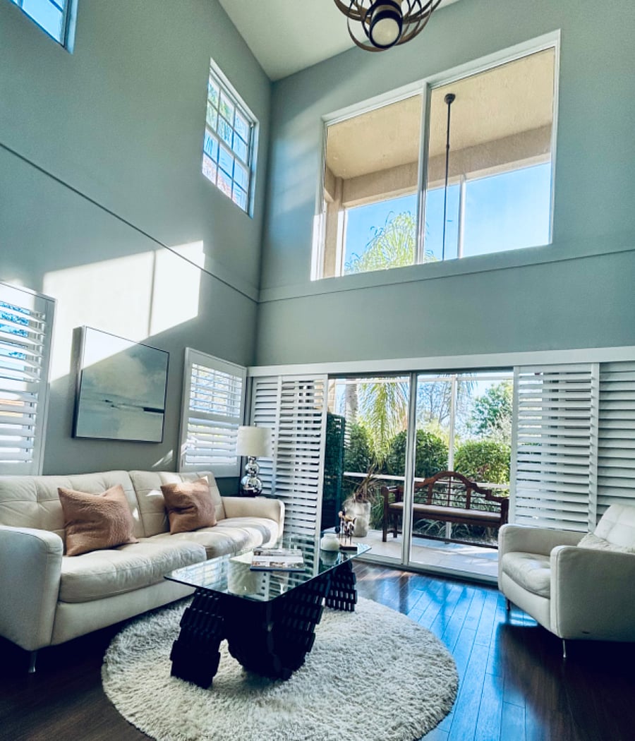 Light-filled living area featuring 20 ceilings and garden views
