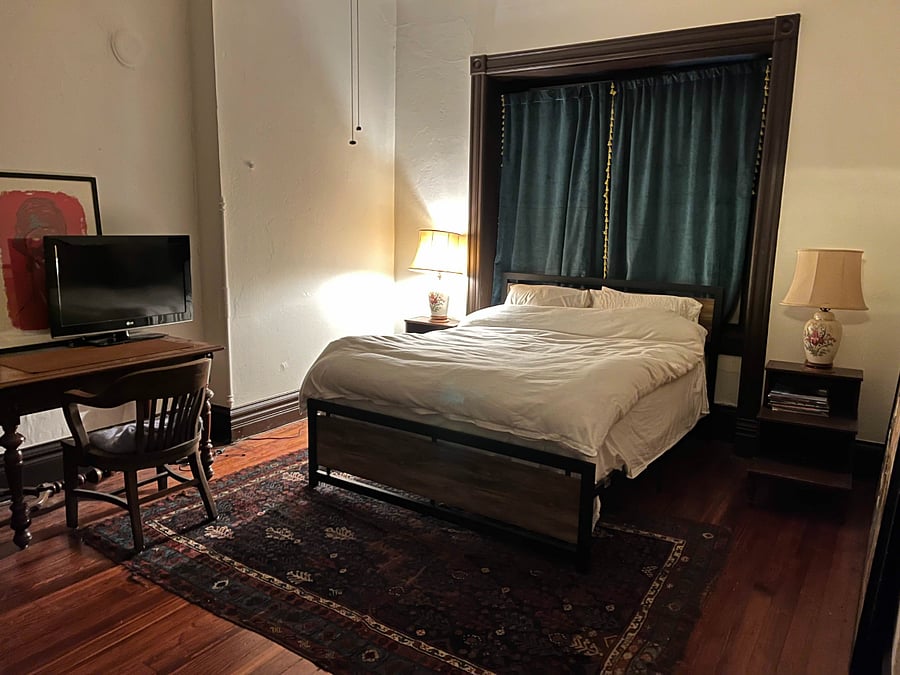 Second Floor Additional Bedroom. Windows on 3 sides, desk, and smart TV. 