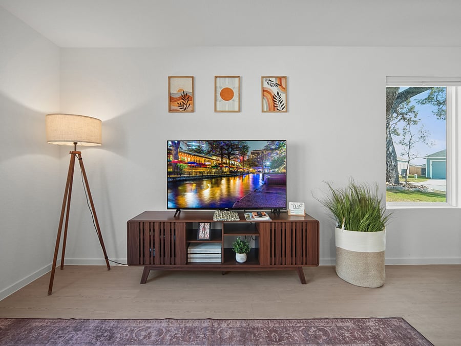 Mid-century charm meets modern convenience in this light-filled living room, complete with a Smart TV and picture window framing peaceful outdoor views.