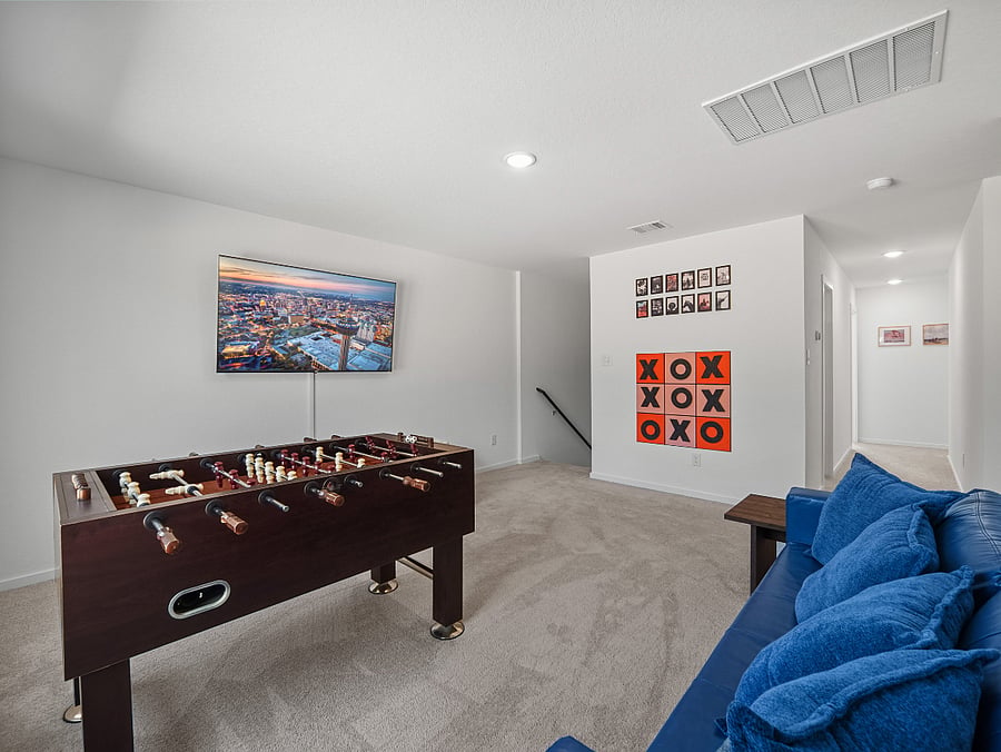 Upstairs game loft featuring a big-screen Smart TV  perfect for movie nights, streaming your favorites, or catching the big game in comfort.
