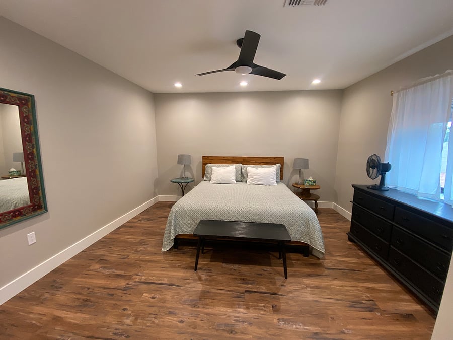 Master bedroom with king-sized bed, large dresser, and double closets