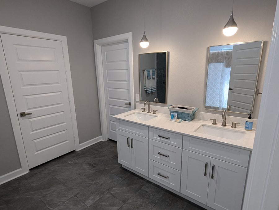The master bathroom features two sinks, a separate walk-in shower, separate tub, detached water closet, and full size closet with iron and ironing board.