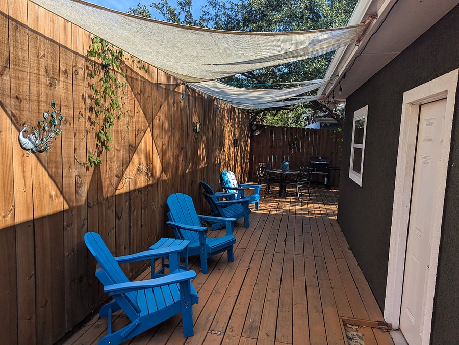 The private back deck features an extra high fence for privacy and multiple chairs for hanging out. Awnings add shade so you can enjoy the patio anytime of day.