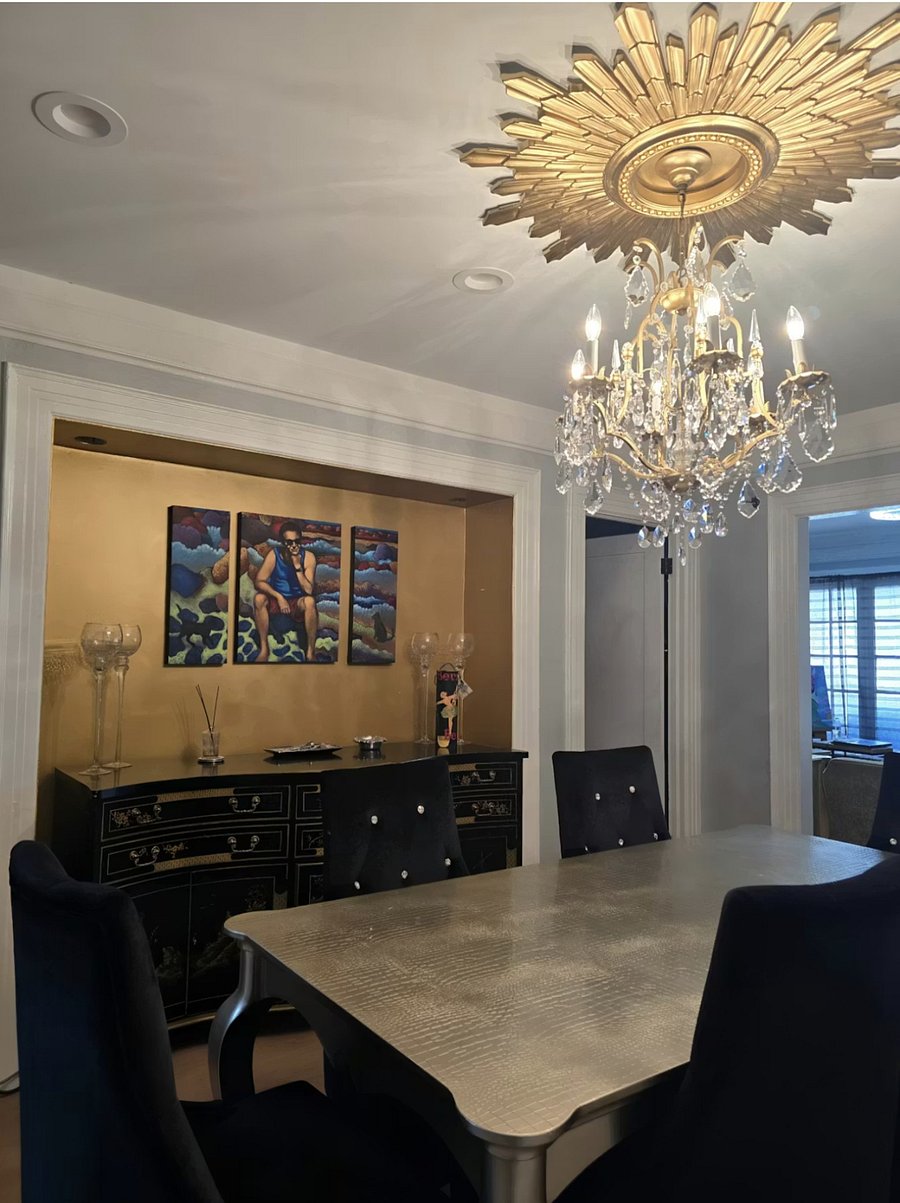 Formal dining room with elegant chandelier and seating for shared meals. It has seating for 810 ideal for meetings and extended stays.