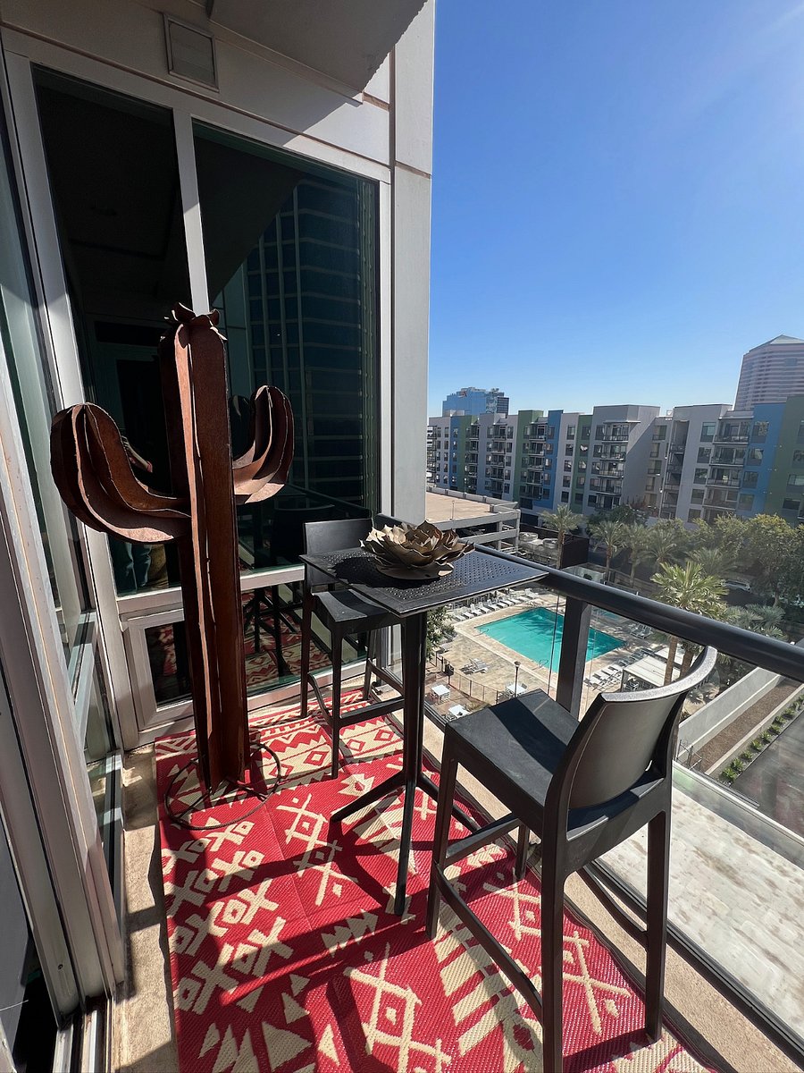 Balcony includes a lounge chair and hightop table with two chairs.