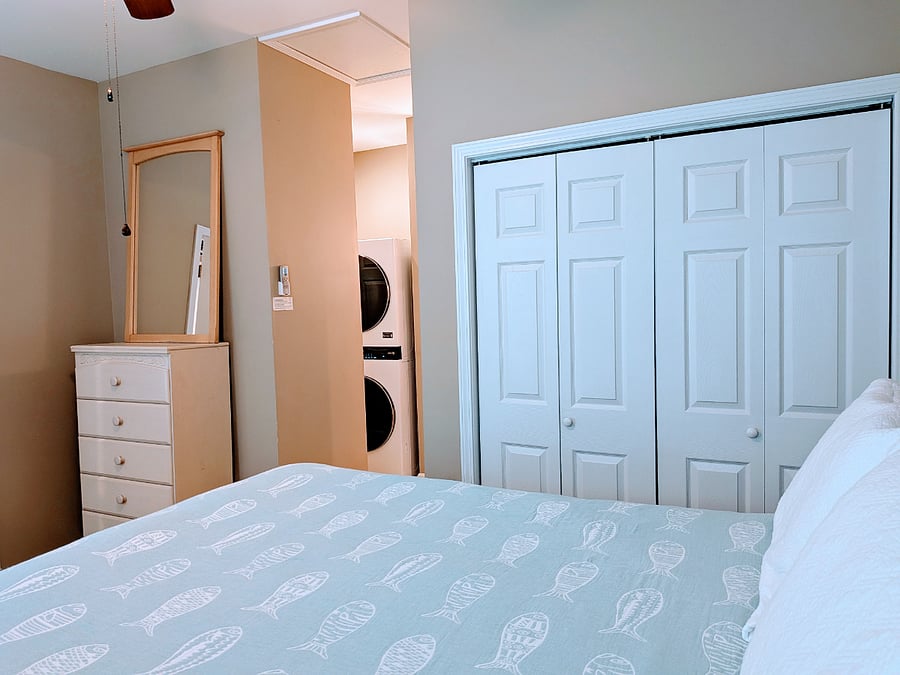 Bedroom view toward closet, dresser, ensuite, laundry area, linen closet
