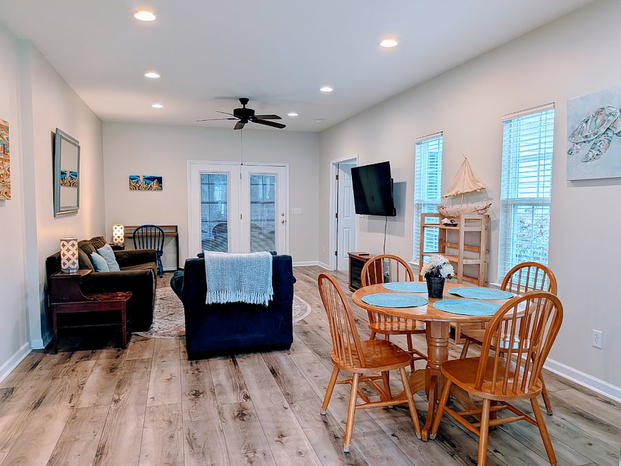 View of living area from entrance, table & chairs, sofa & armchair, desk & chair, TV & shelves