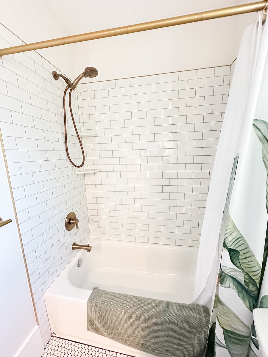 Clean, modern bathroom with full-size shower/tub, tiled floors, and linens included for stress-free monthly rental.