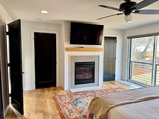 Master bedroom with 55 inch smart TV over gas fireplace