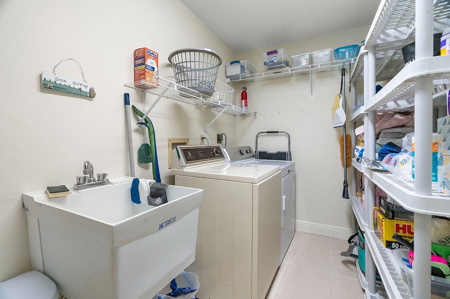 Laundry room with storage and cleaning supplies.