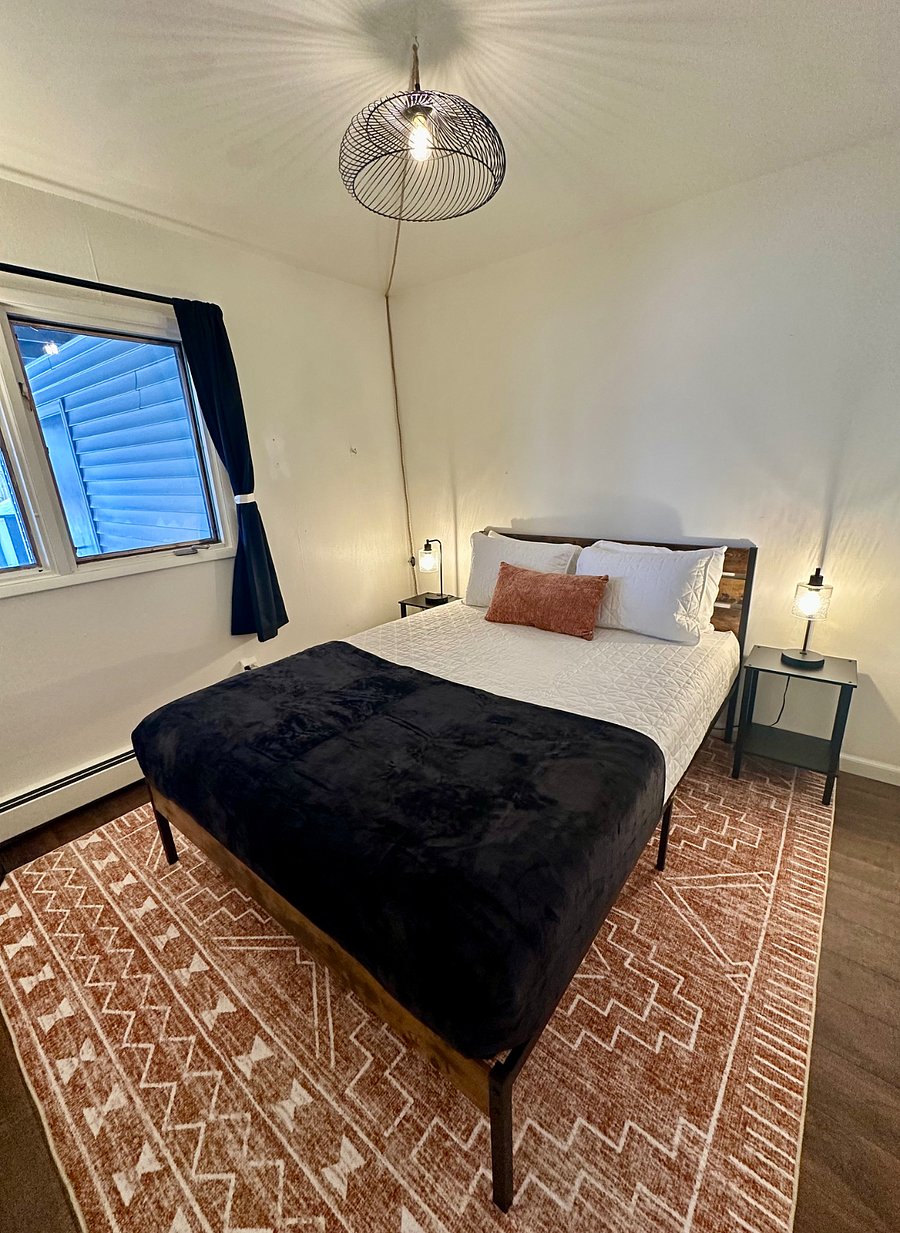 Second bedroom (ground-level, abutting carport) with Queen bed, crisp quilted bedding, soft cotton sheets, cozy blanket, blackout curtains, and plenty (four) of pillows for a great sleep! Not pictured: in-room closet.