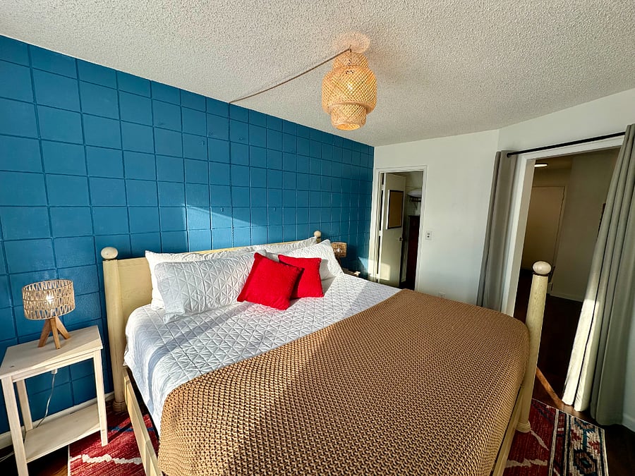 Alternate view of bedroom with King bed, showing attached walk-in closet and hallway entry.