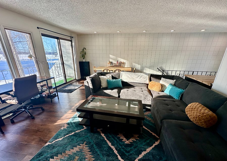 Spacious and bright "open concept" living room (upstairs) with comfy sectional and Smart TV; dining area with seating for four; and dedicated workstation with lake views.
