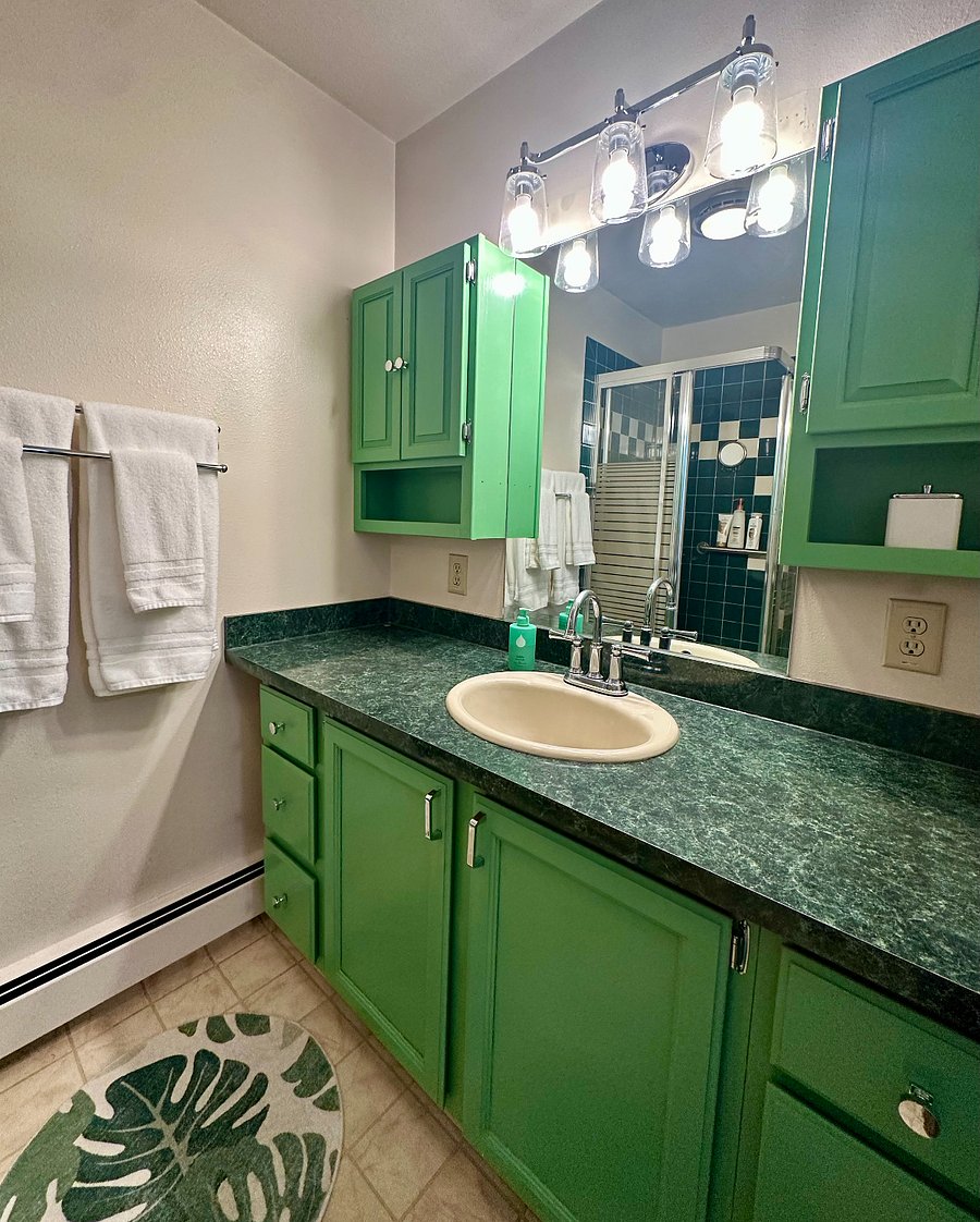 Go green in the full bathroom (ground floor). There's a large vanity with lots of counterspace and cabinet storage.