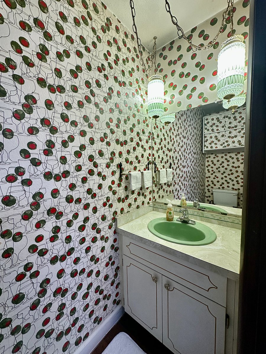 The funkiest half bath (upstairs) you ever did see, complete with the original vintage 1970s martini wallpaper, green sink, and milk glass pendant lights.