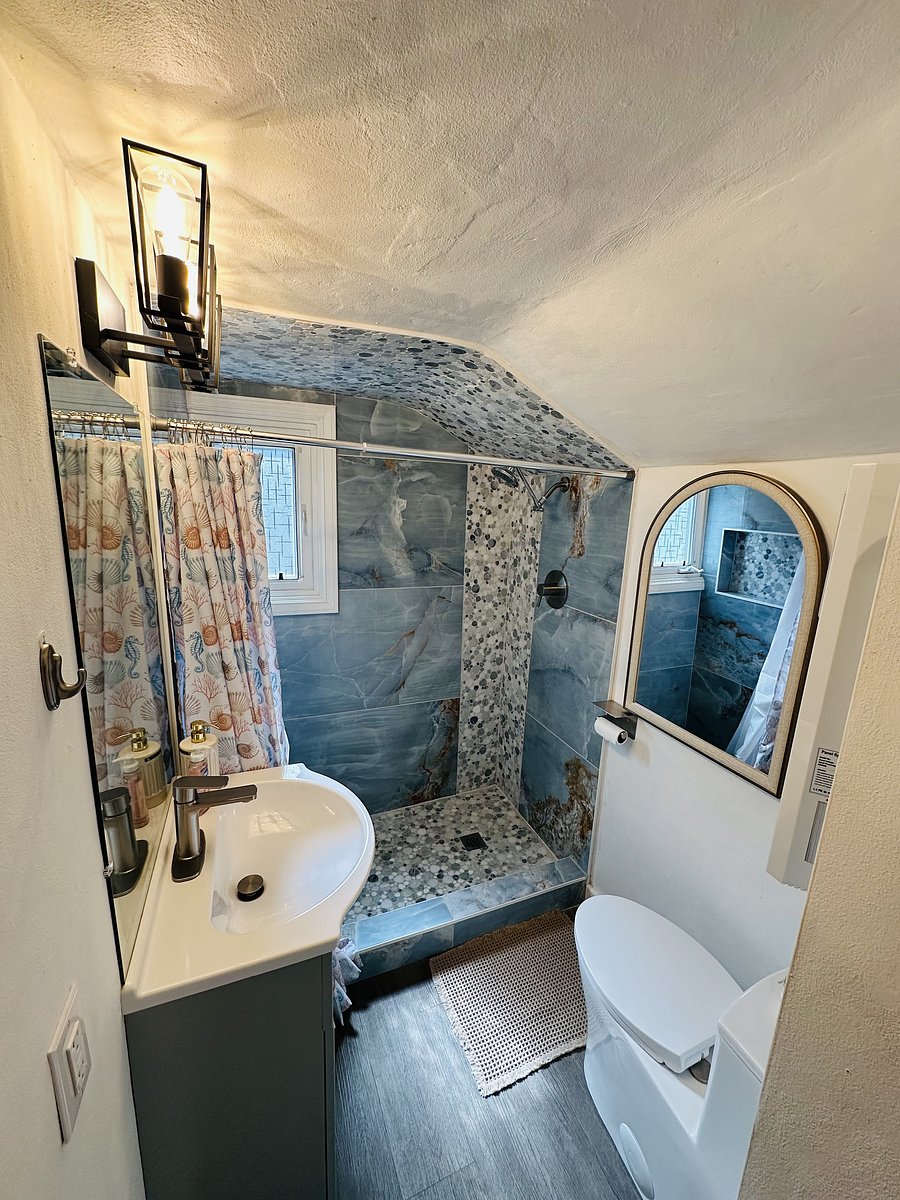 Shared Upstairs Bathroom - Clean and updated bathroom with walk-in shower, sink, mirror, and convenient access from both upstairs bedrooms.