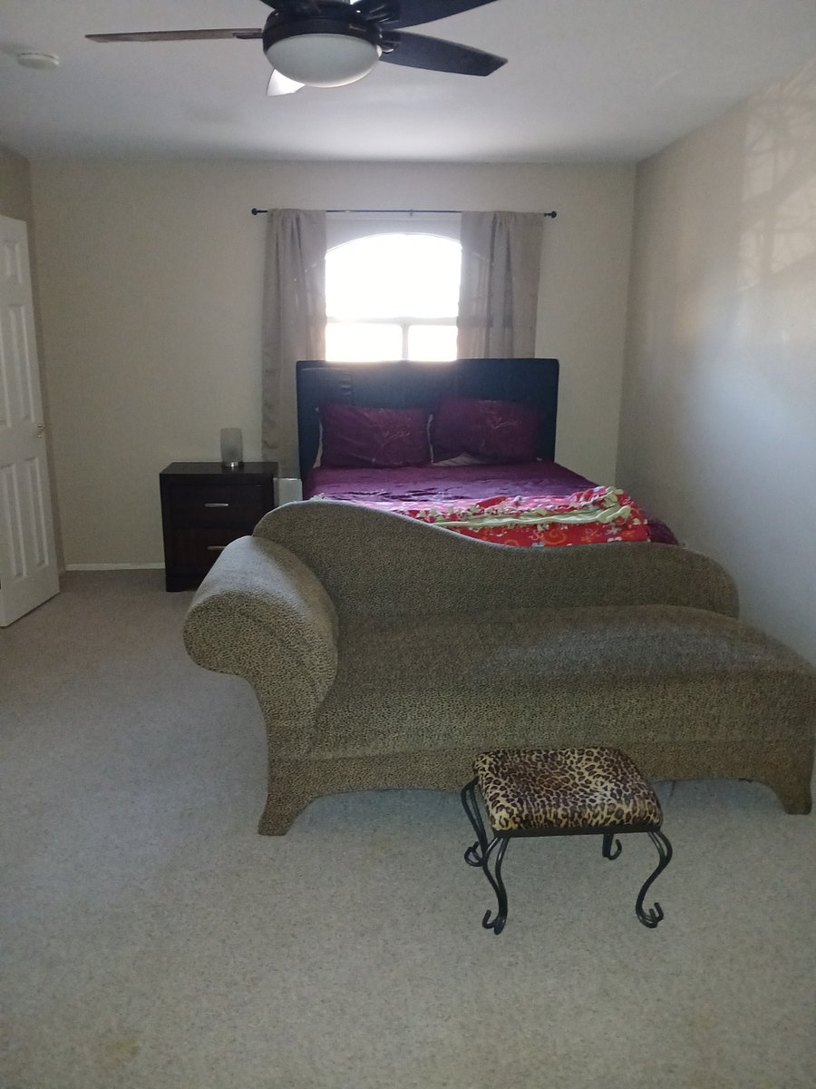 Master room queen bed with a chaise to relax and watch tv with black out curtains with walkin closet.