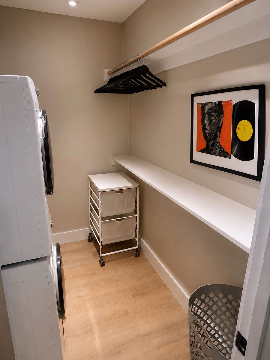 Oversized walk-in closet with plenty of storage space, full-size washer and dryer, and modern track lighting
