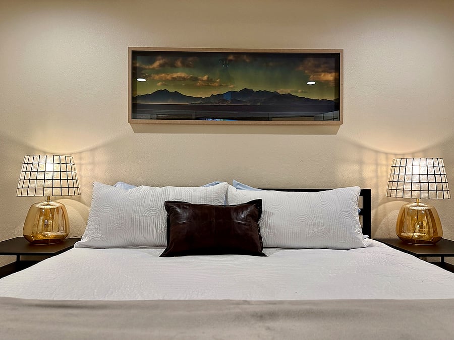Spacious bedroom with king bed, blackout curtains, and designer lighting, a cozy sleep retreat with luxury bedding for extended stays.