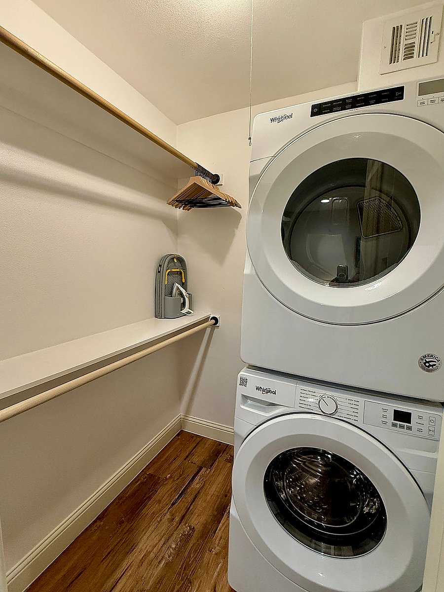 Spacious walk-in closet with full-size in-unit washer & dryer, essential for long-term stays