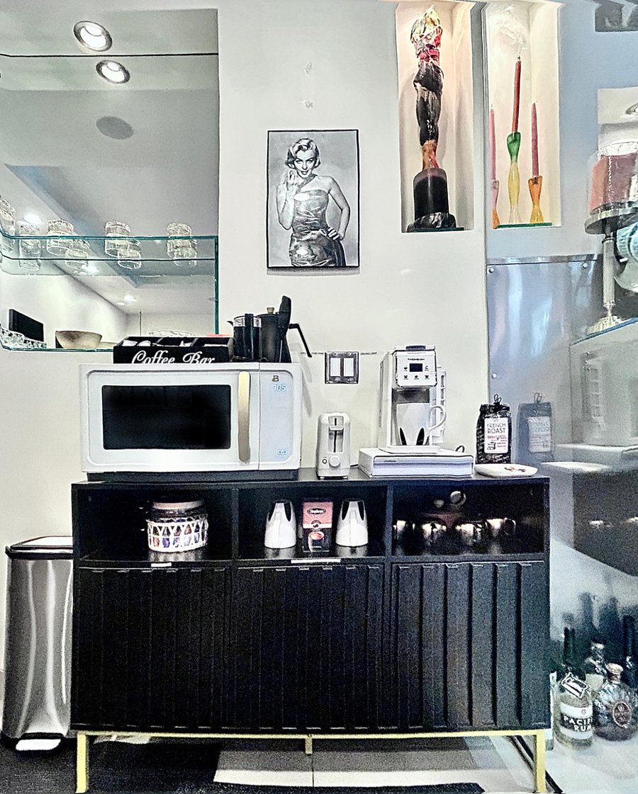 Coffee station with toaster, microwave and cabinets for storage and appliances.