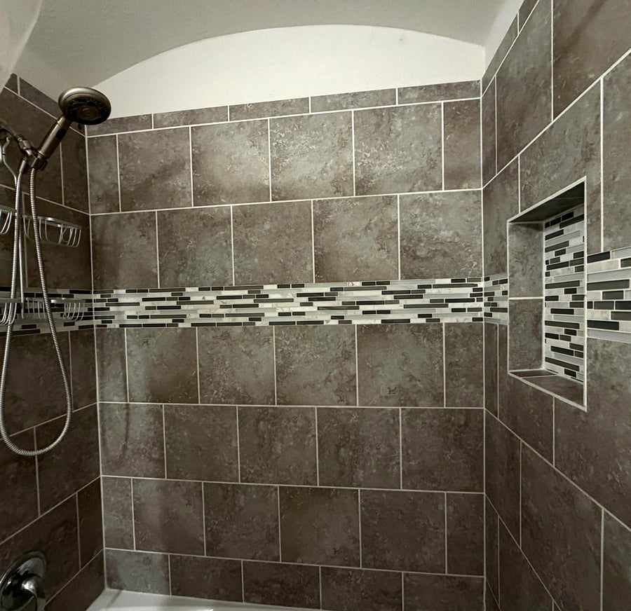 Updated tiled shower with built-in storage niche