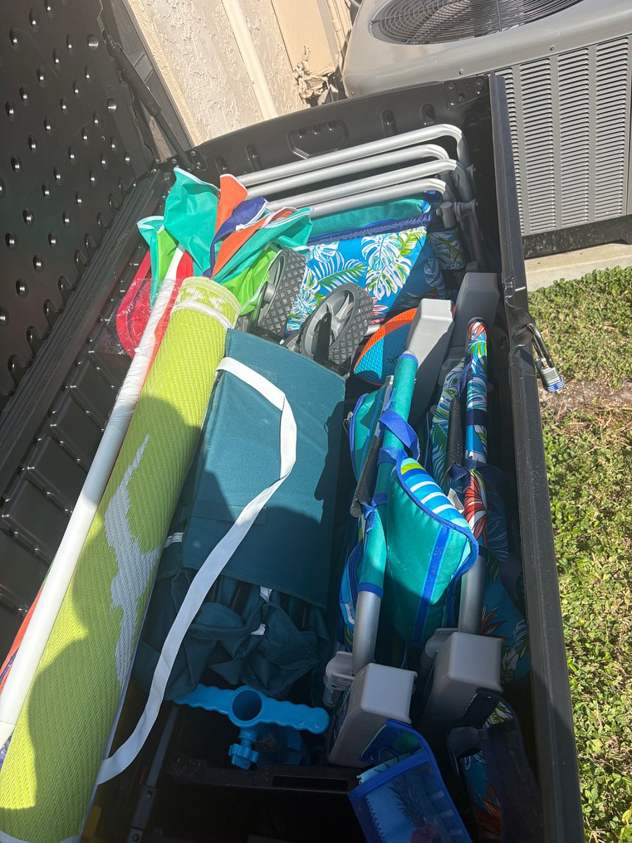 Storage box outside of lanai with 4 beach chairs, beach wagon, sun shade and pickleball rackets
