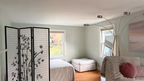 Living room downstairs with queen bed, couch, and fireplace