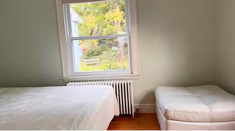Living room downstairs with queen bed, couch, and fireplace