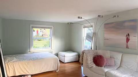 Living room downstairs with queen bed, couch, and fireplace