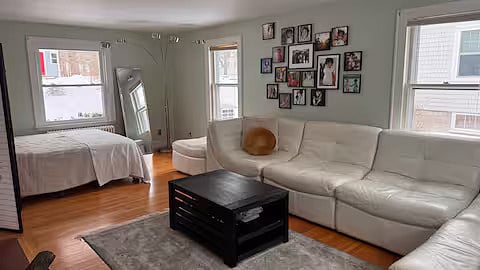 Living room downstairs with queen bed, couch, and fireplace