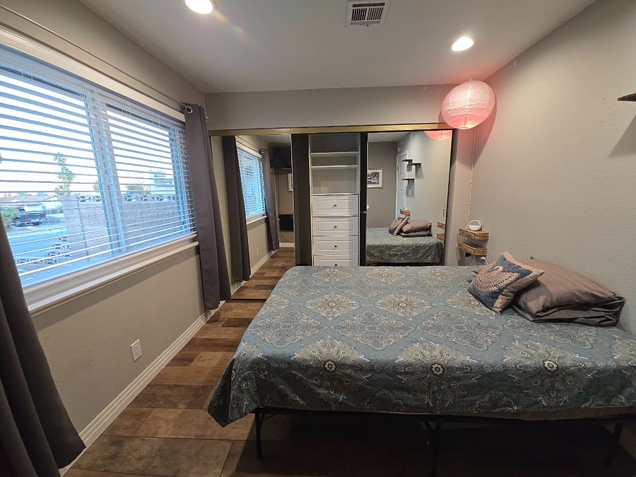 Guest Bedroom (window to front yard), sliding mirror doors lead to closet on entire wall