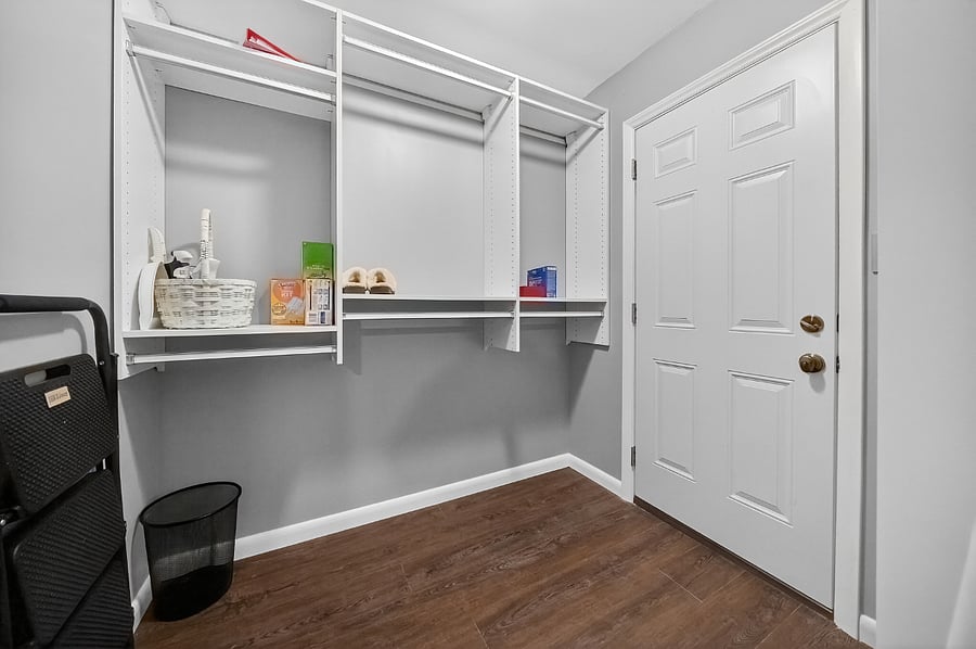 Primary walk-in closet with built-in shelving.