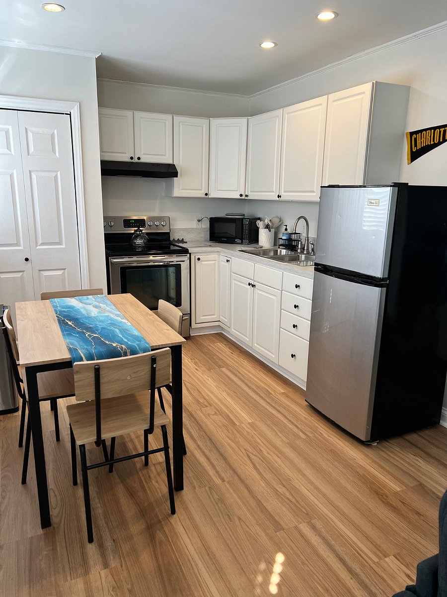 Kitchen area with table and four chairs, refrigerator with freezer, microwave, oven and stove.