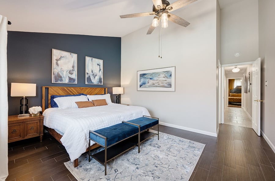 The Blue Room Primary bedroom featuring vaulted ceilings and pool views . large king bed, oversized nightstands, 2 closets, ceiling fan.