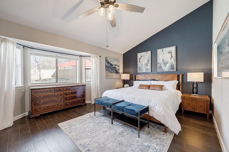The Primary Bedroom. The Blue Room features a spacious suite with a King size bed, vaulted ceilings, dual closets and in suite bathroom. The bay window provides views of the pool and backyard. The Benjamin Moore Hale Navy blue accent wall provides for calming relaxation.