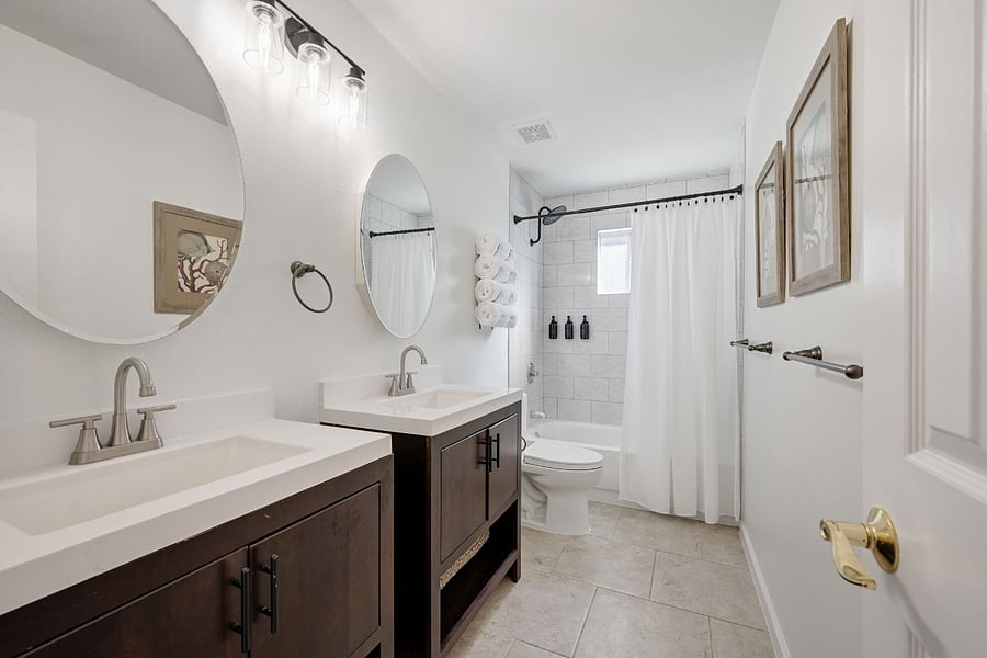 Hallway main bathroom: Features two separate sinks and medicine cabinets and tub/shower combination.