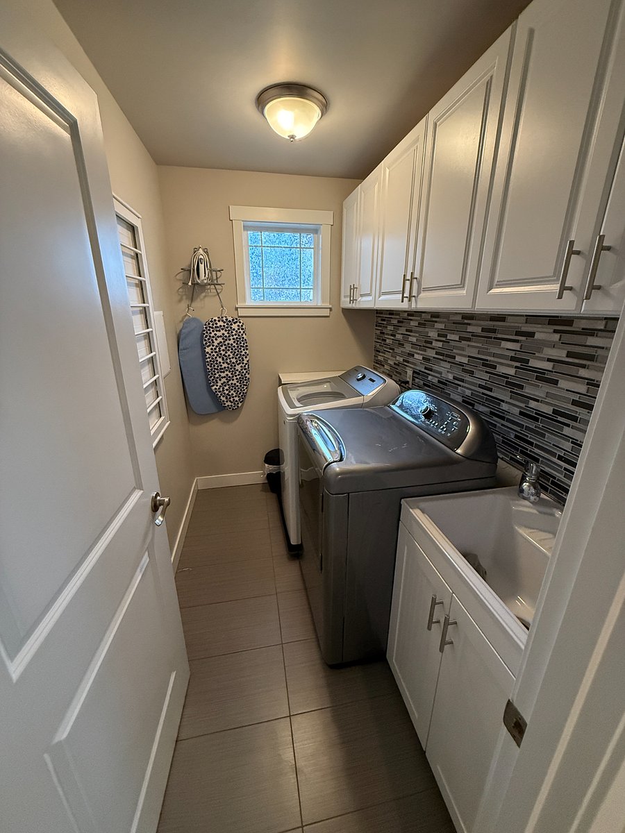 Upstairs laundry room with utility sink.