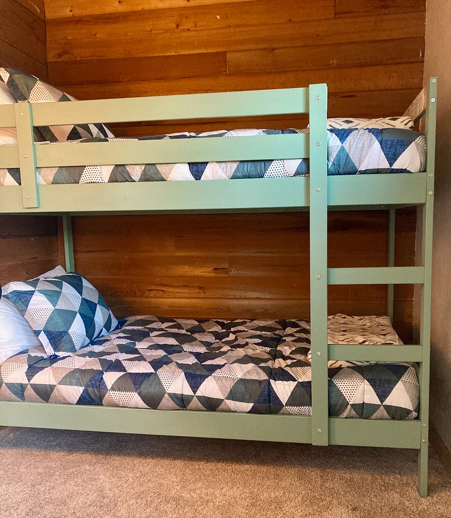 Cozy cedar plank bunk room with two twin beds.