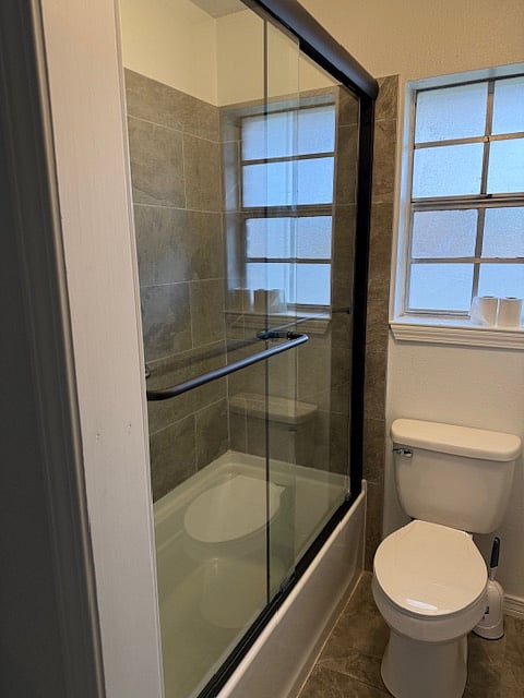 Bath/Shower with glass door and flex shower head.