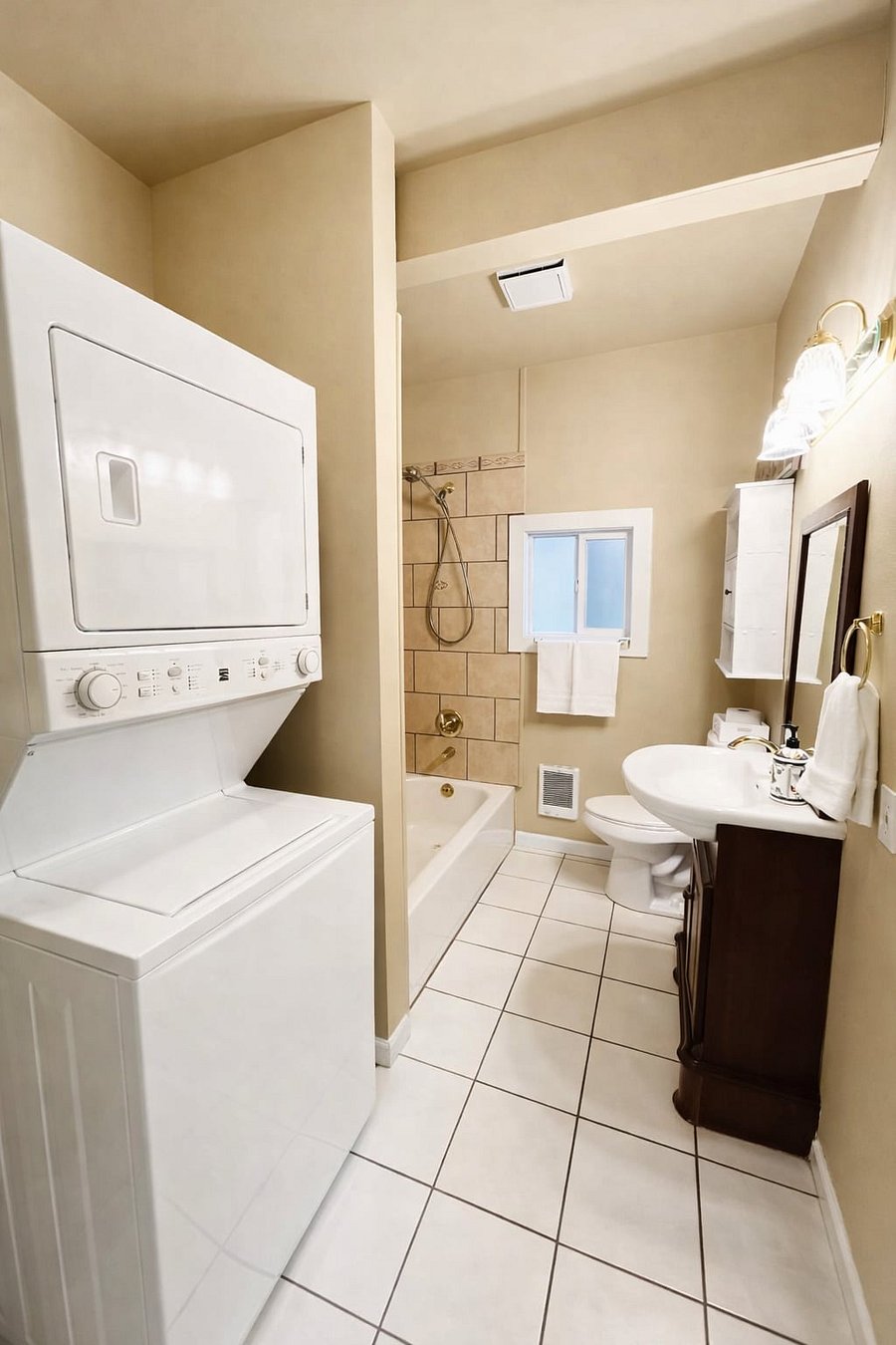 Full bathroom with soaking tub, private in-unit washer and dryer, and a window for fresh air and sunlight.