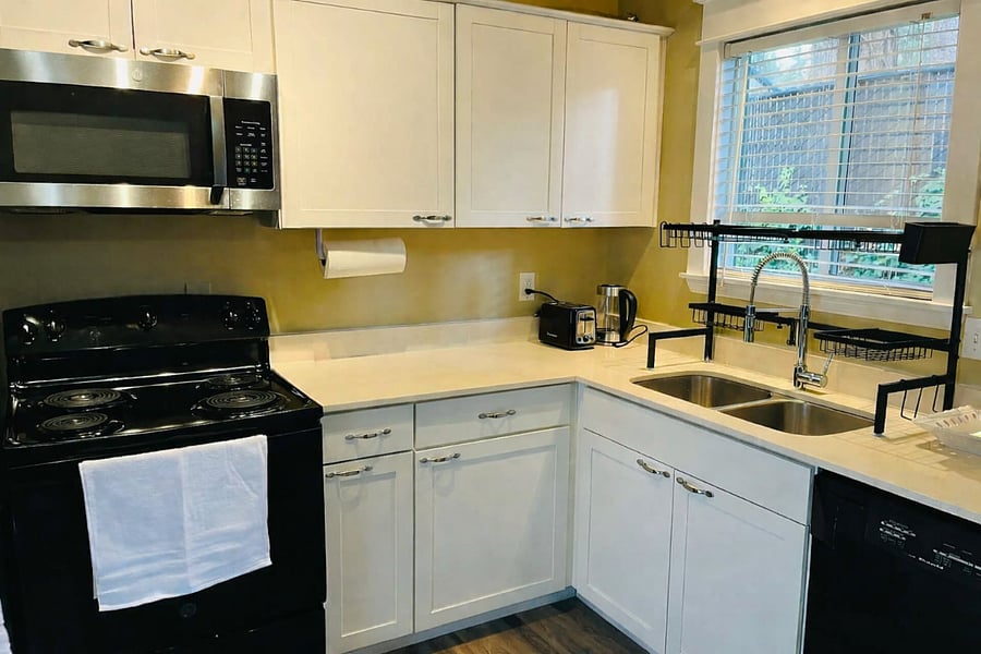 Fully equipped kitchen featuring All-Clad stainless steel pots and pans.