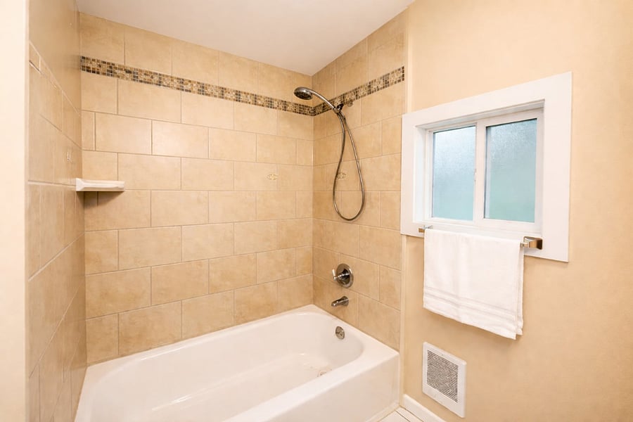 Full bathroom with soaking tub, private in-unit washer and dryer, and a window for fresh air and sunlight.
