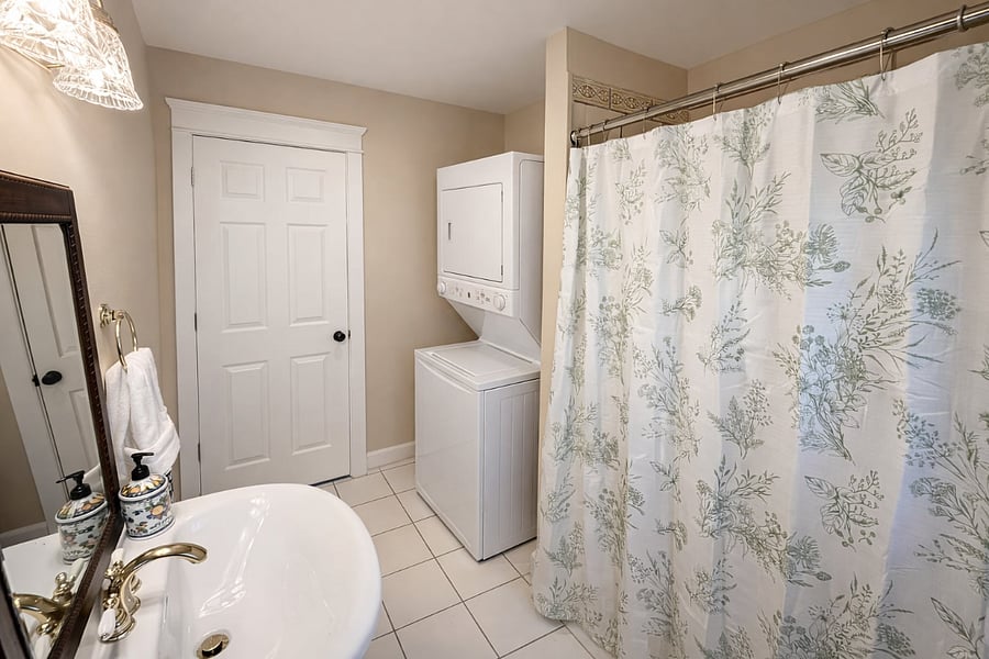 Full bathroom with soaking tub, private in-unit washer and dryer, and a window for fresh air and sunlight.